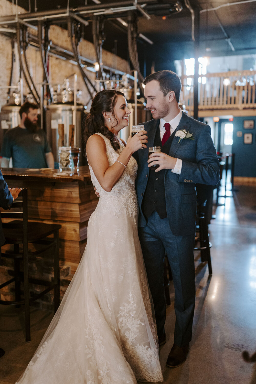 Fun bride and groom get fresh beers from local brewery on their fall wedding day