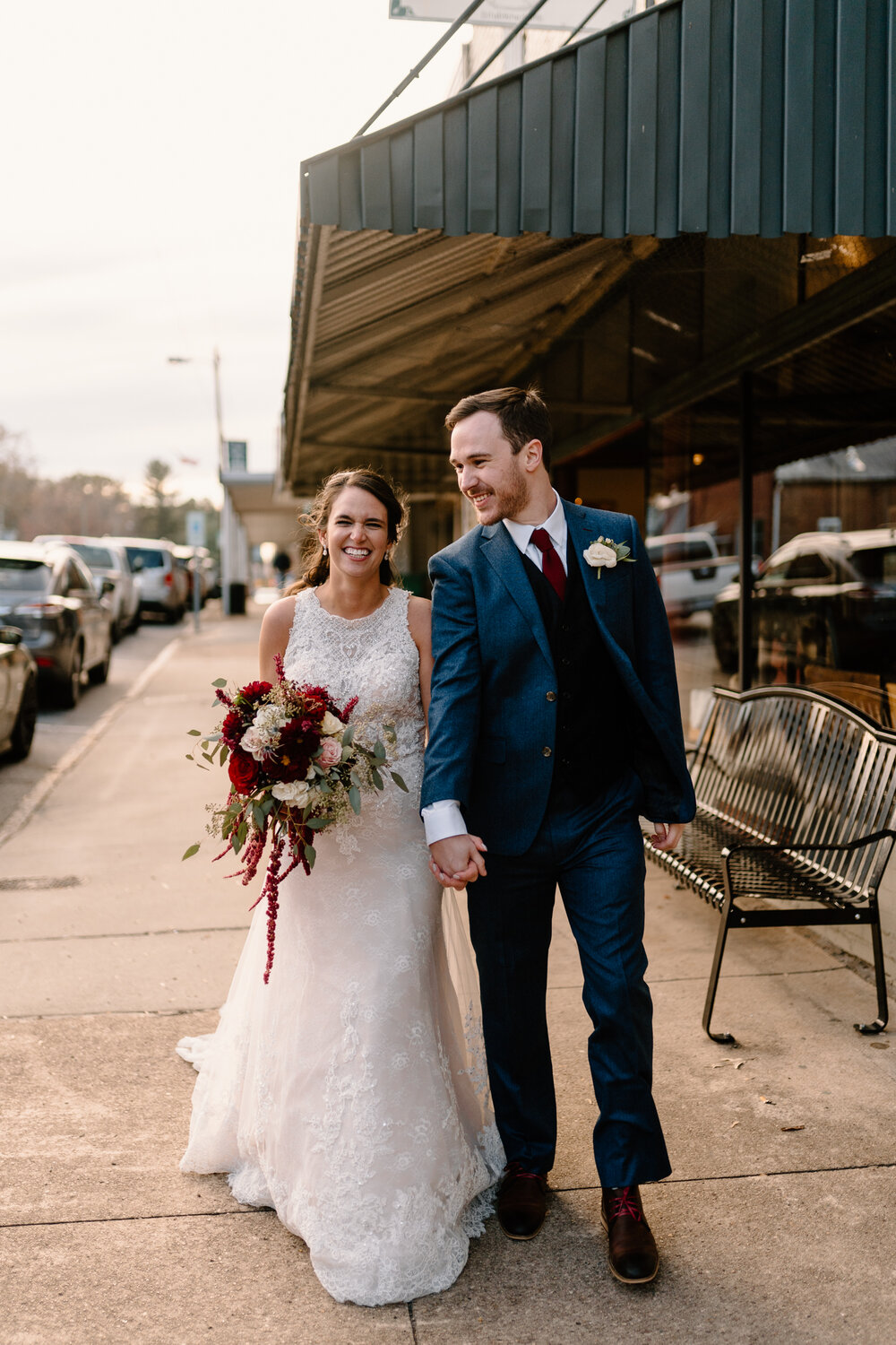 Newlyweds walk hand in hand on their fall wedding day in Winston-Salem, NC