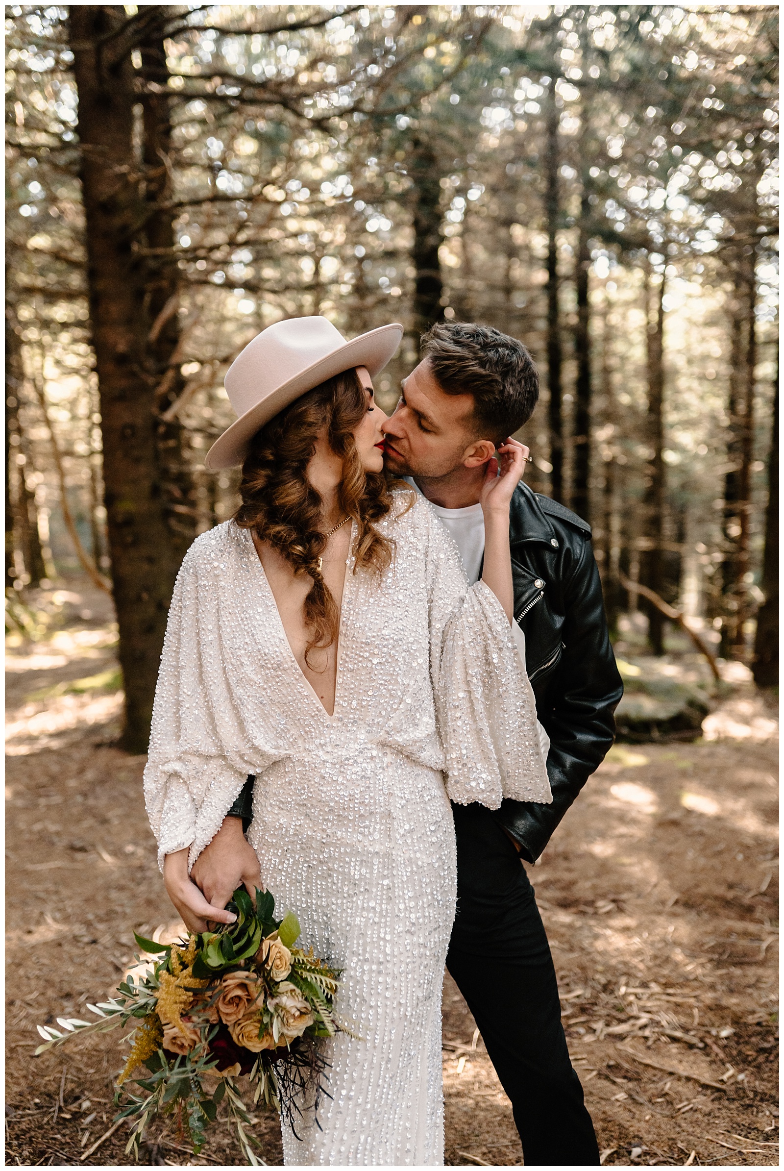 bride and groom share a kiss during Boho styled adventurous elopement in the Ashville NC woods