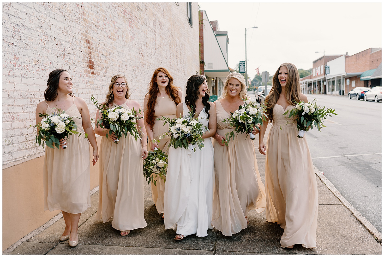 Bridesmaids walking and laughing with bride in historical downtown NC