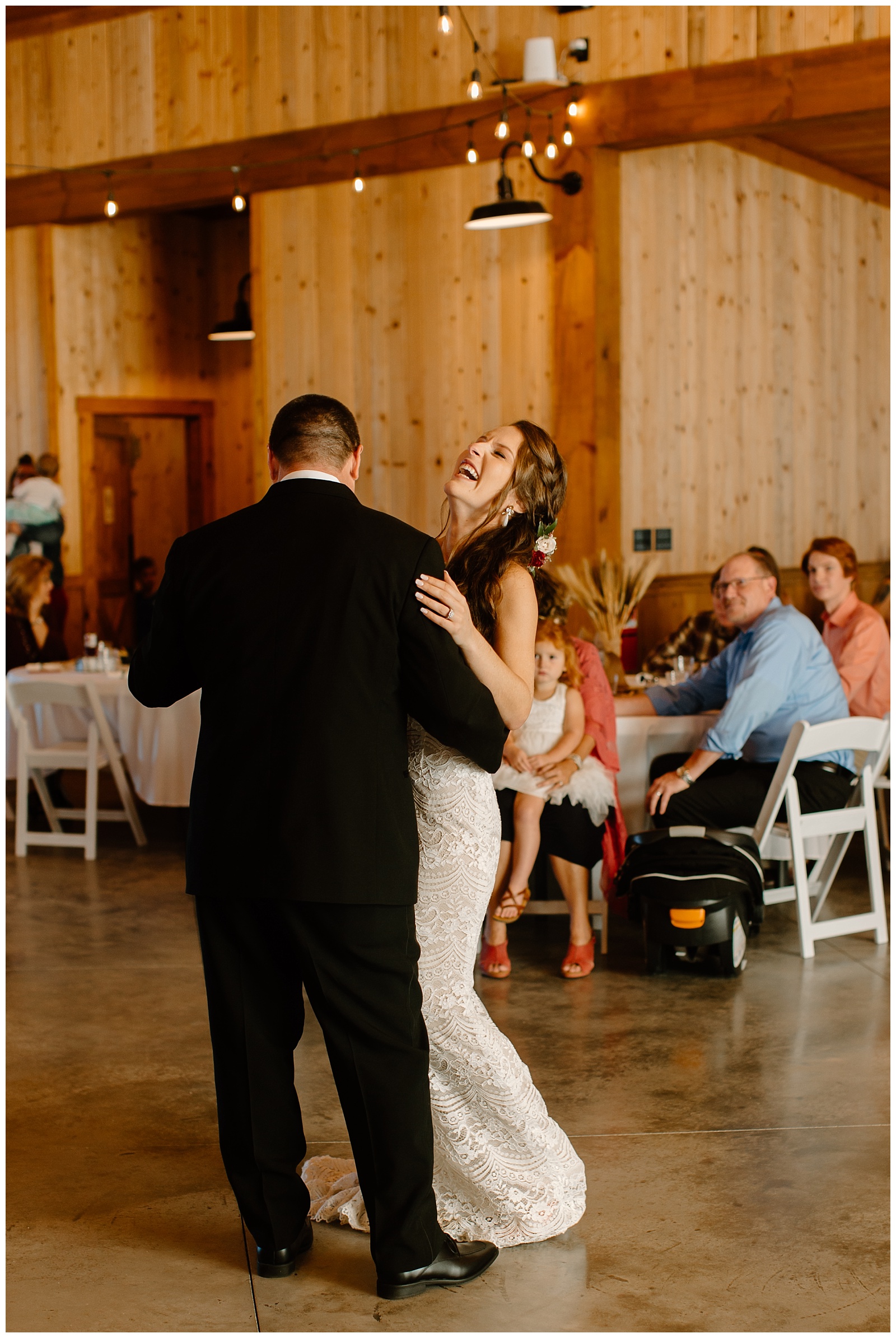 Bride's father makes her laugh during their special father daughter dance at their wedding reception