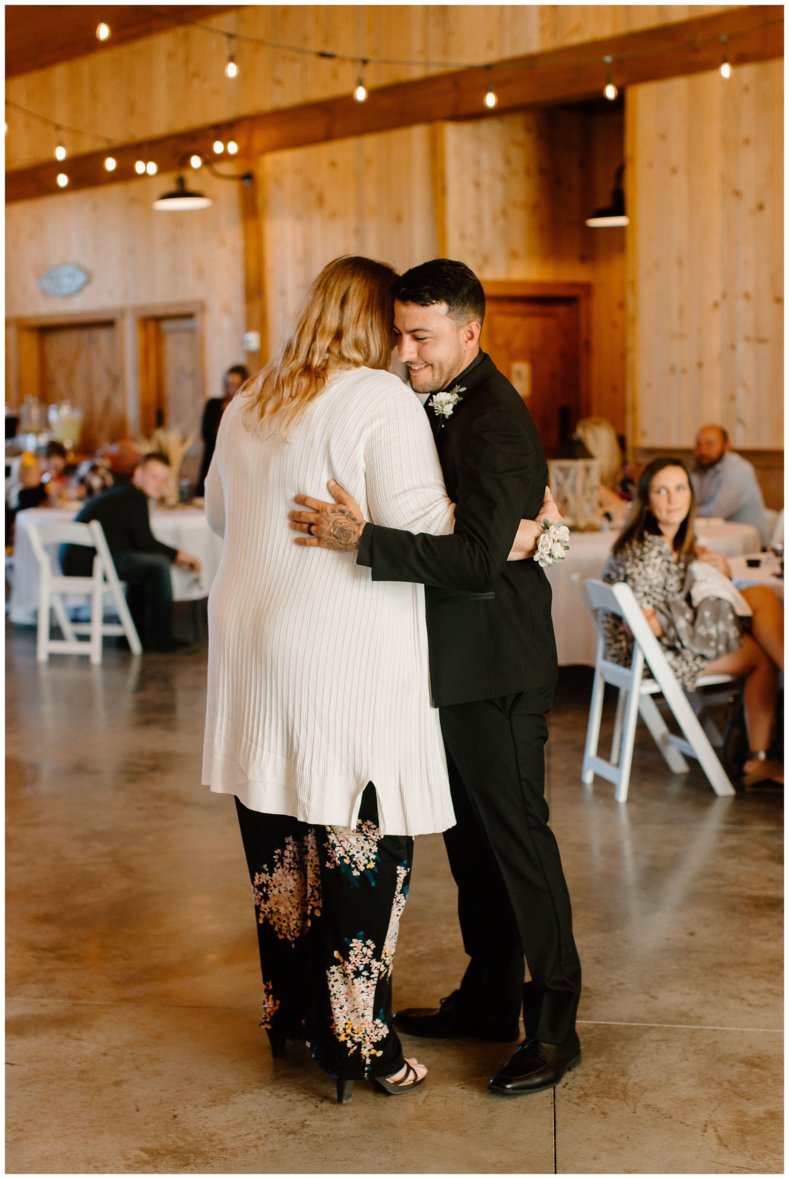 Groom holds his mom close during the mother son dance at his wedding reception