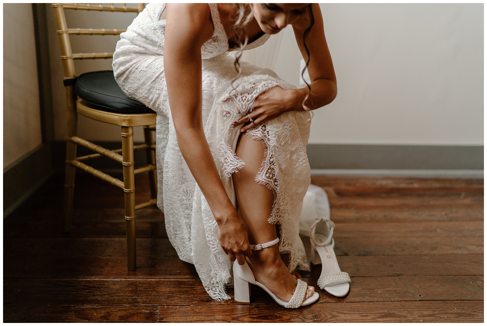 Bride getting ready portraits putting her shoes on, lace gown details