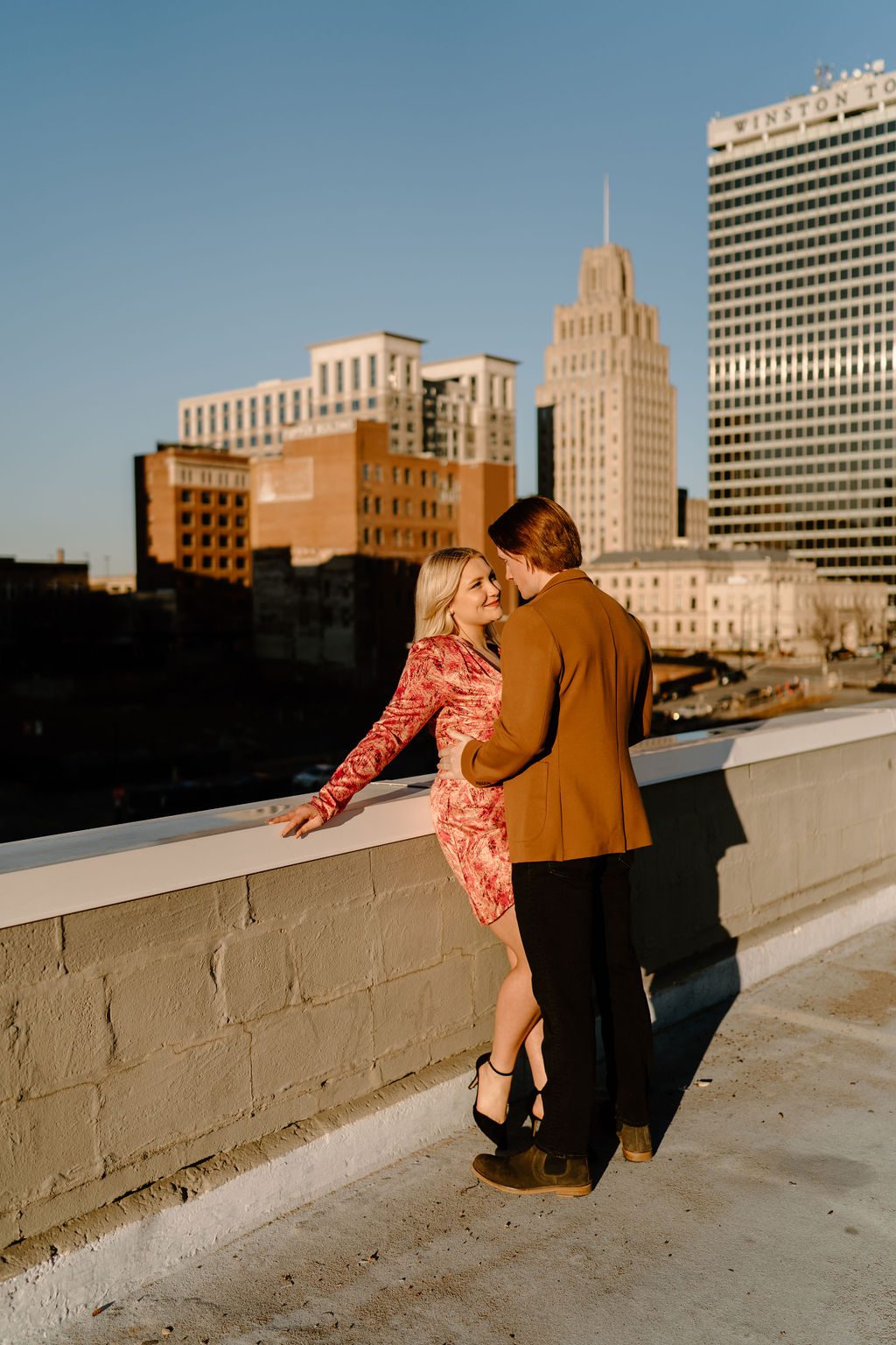 steamy engagement photos on rooftop of downtown north carolina
