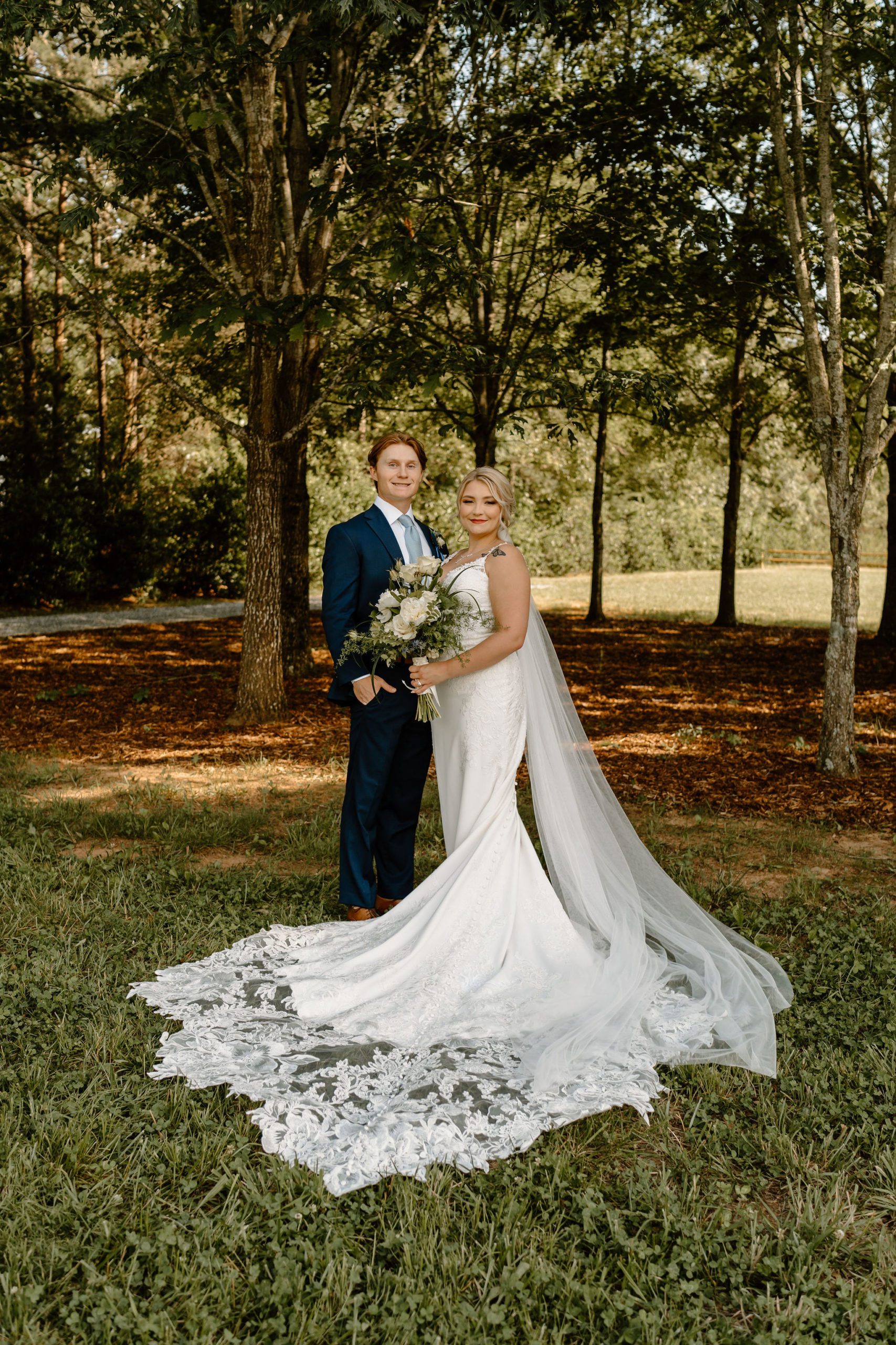 Bride and groom with white flowers, elegant wedding decor and beautiful lace wedding dress in North Carolina
