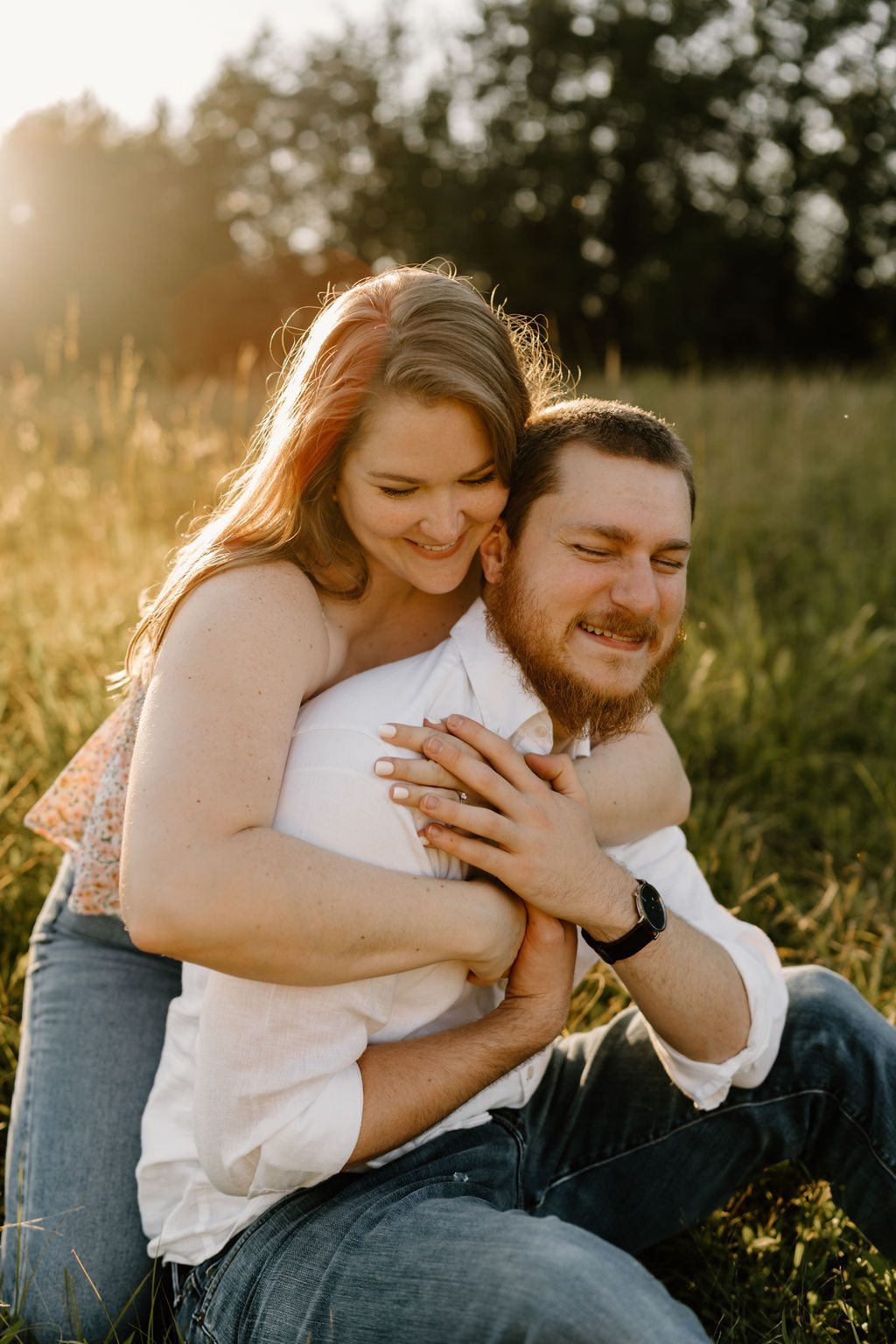 Couple hugging in an open field in North Carolina with golden hour light 
