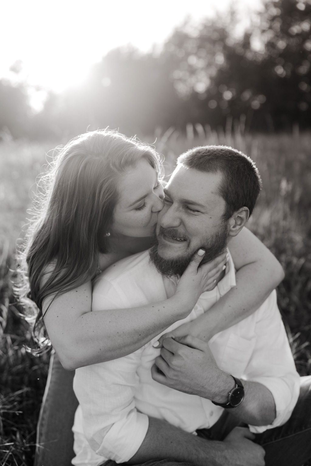 Couple hugging in open field in North Carolina with golden hour light 
