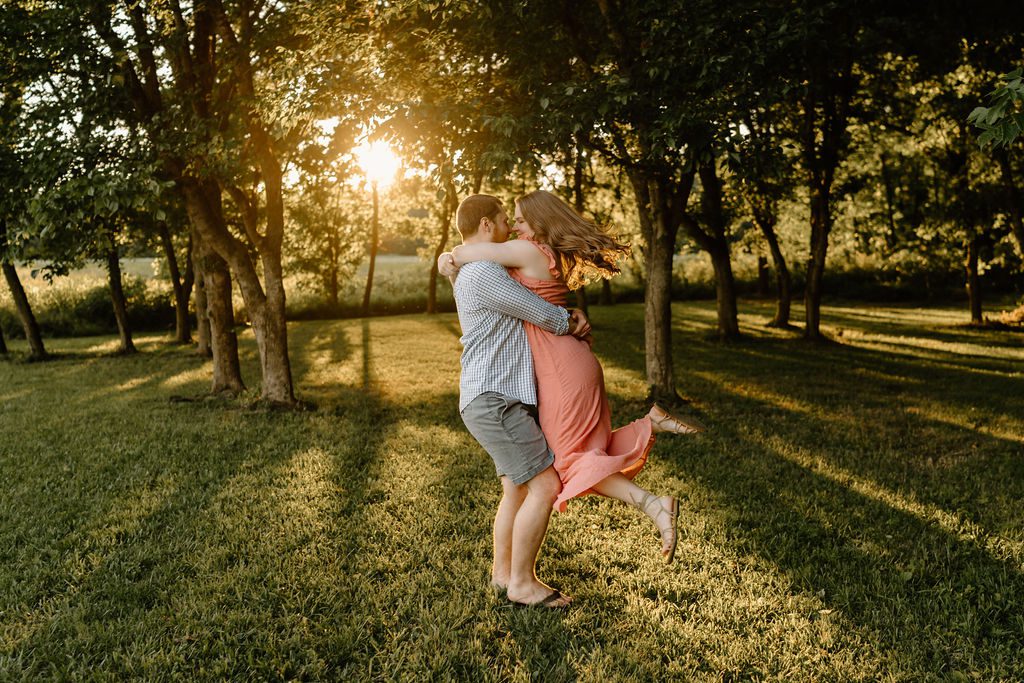 Couple running through open field in North Carolina with golden hour light 
