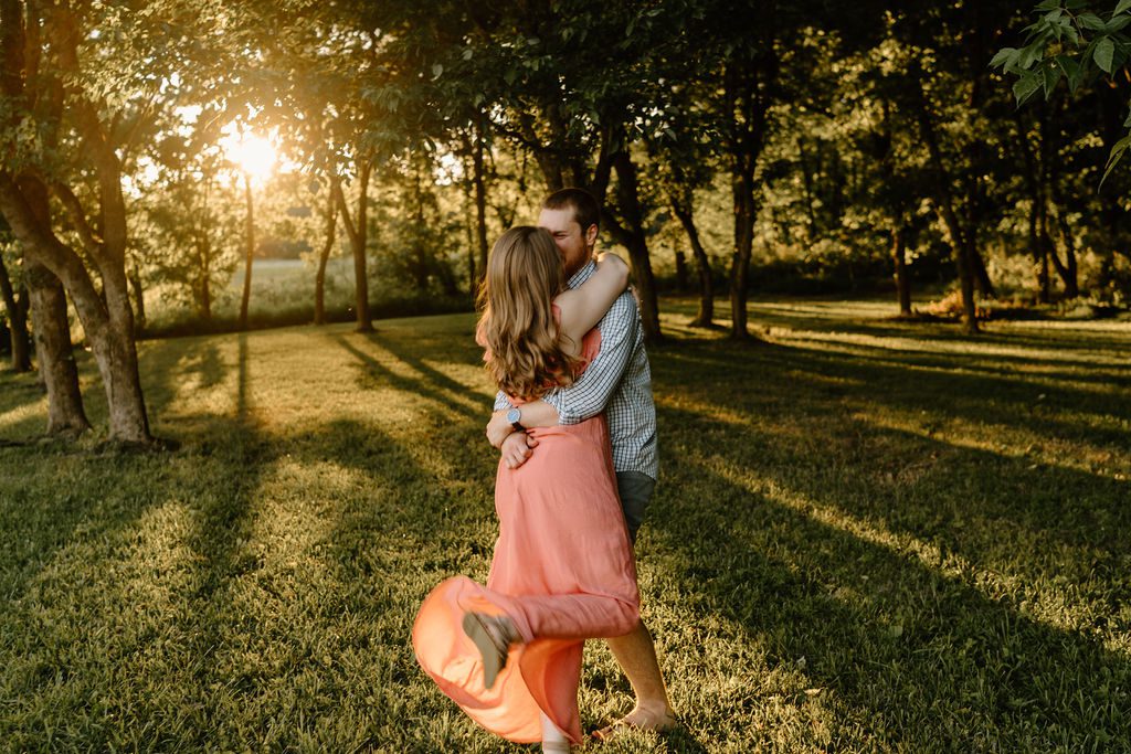 Couple holding hands during golden hour in Winston Salem North Carolina with beautiful long pink dress and casual mens outfit 
