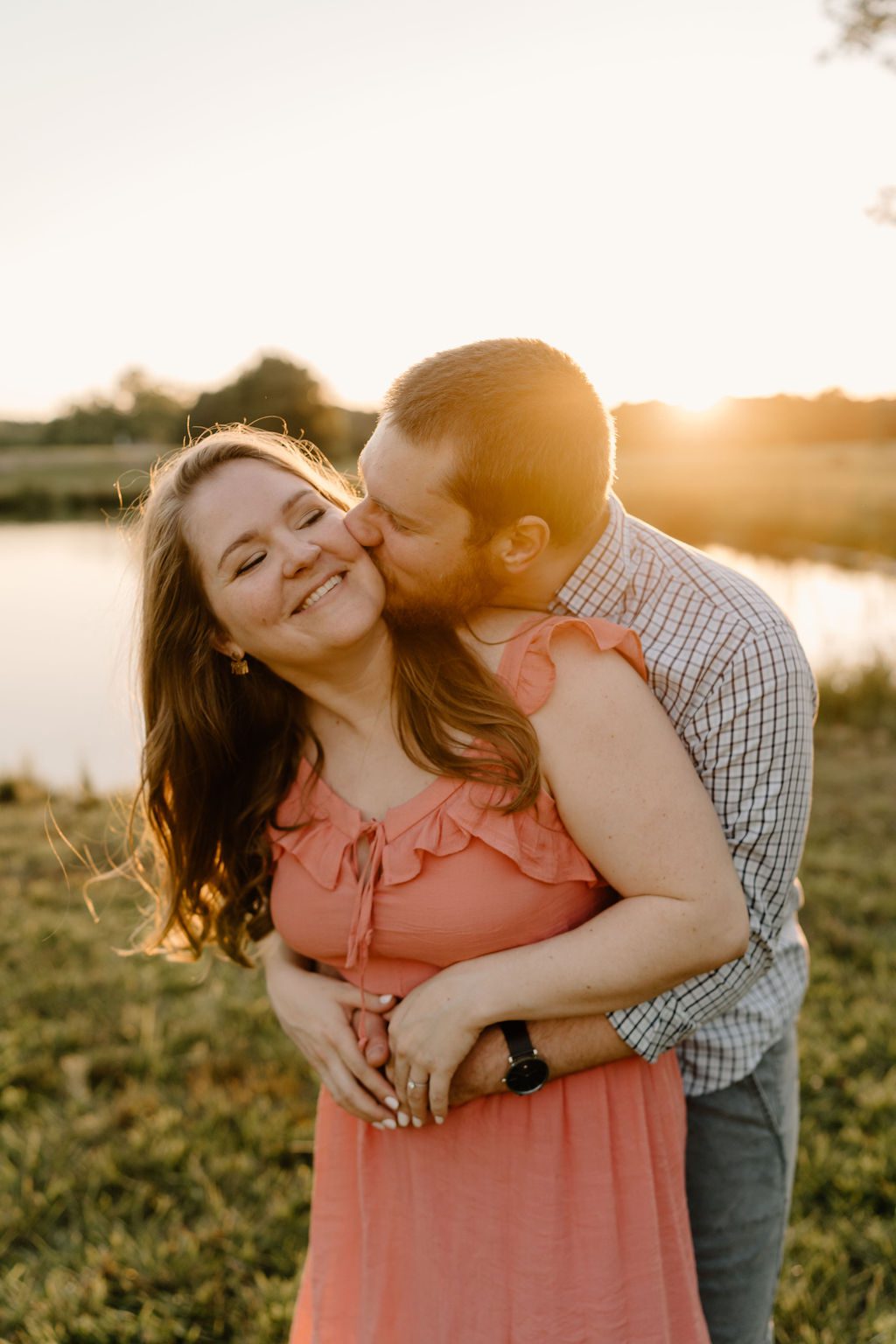 Couple hugging during golden hour in Winston Salem North Carolina with beautiful long pink dress and casual mens outfit 
