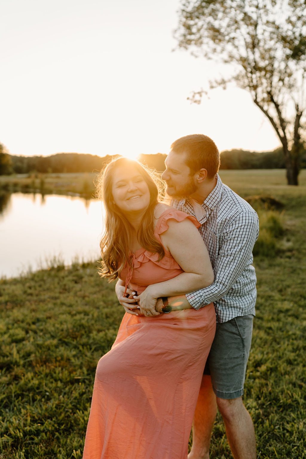 Couple hugging during golden hour in Winston Salem North Carolina with beautiful long pink dress and casual mens outfit 

