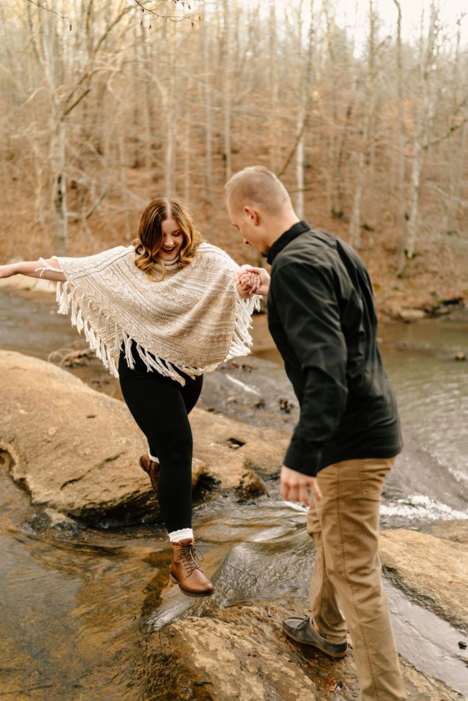 Couple climbing rocks during photoshoot in North Carolina