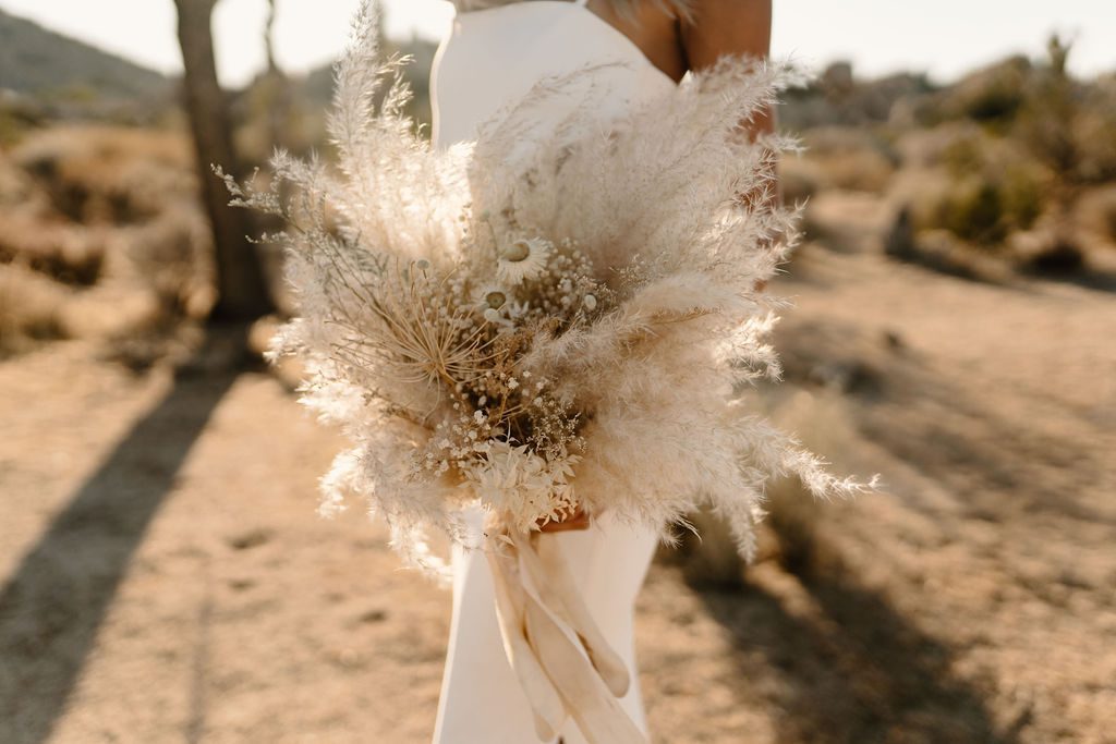 bride posing for photos with boho dried pampas