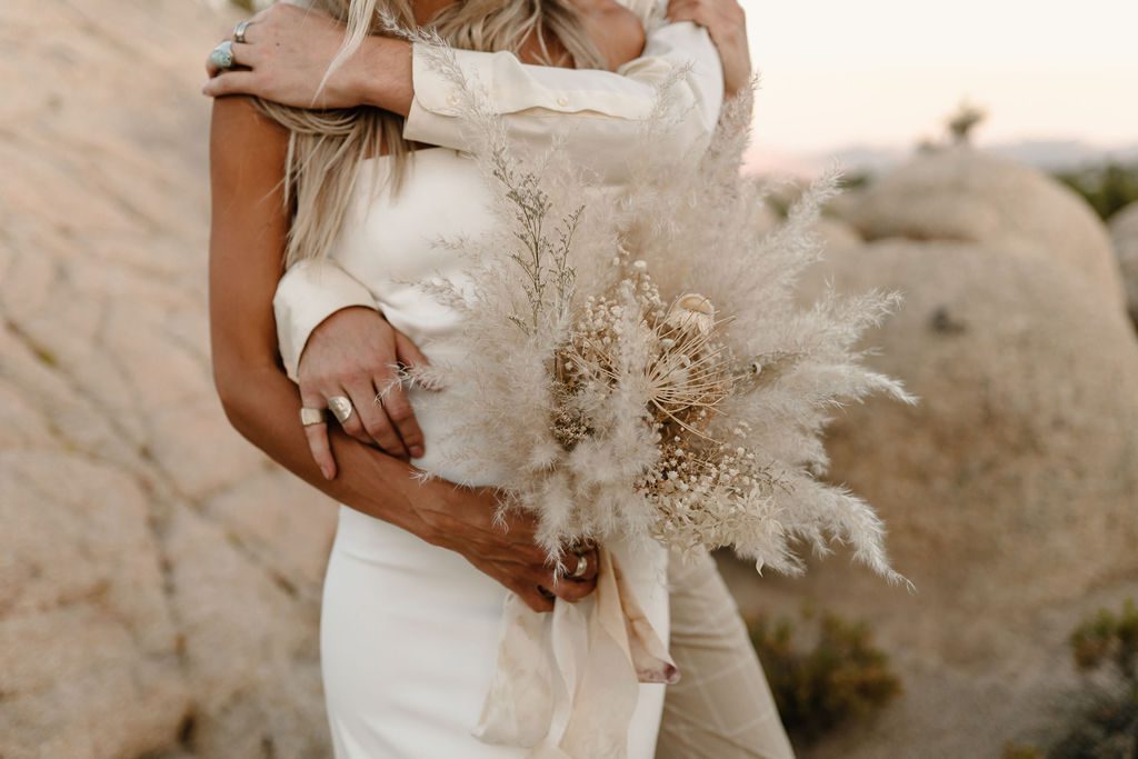bride and groom posing for photos in joshua tree