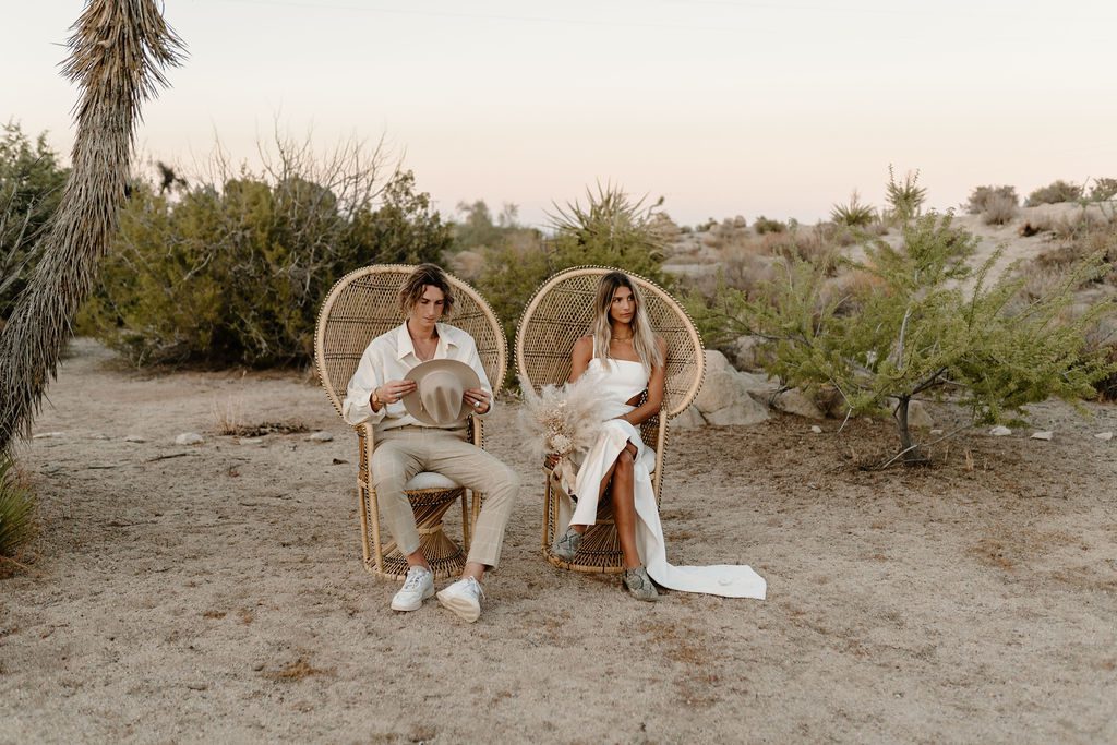 Couple sitting in chairs for photos during destination Joshua Tree elopement in California 