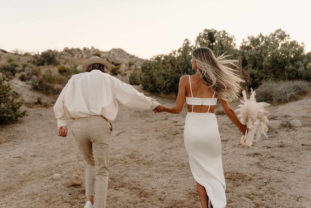 couple running away from the camera for elopement photos