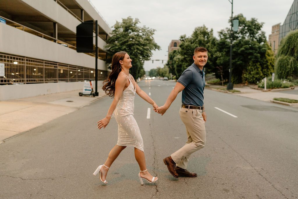 Couple posing for city engagement photos in downtown Winston-Salem