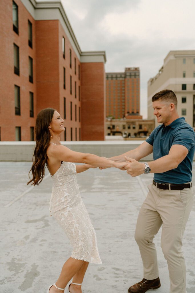 Couple posing for city engagement photos in downtown Winston-Salem